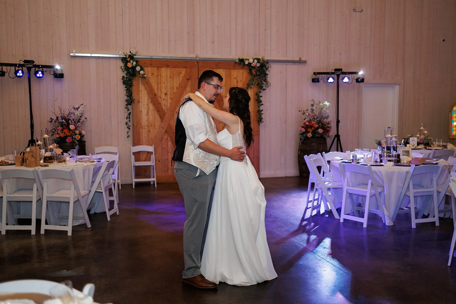 Couple sharing their first dance inside The Heritage Barn reception space