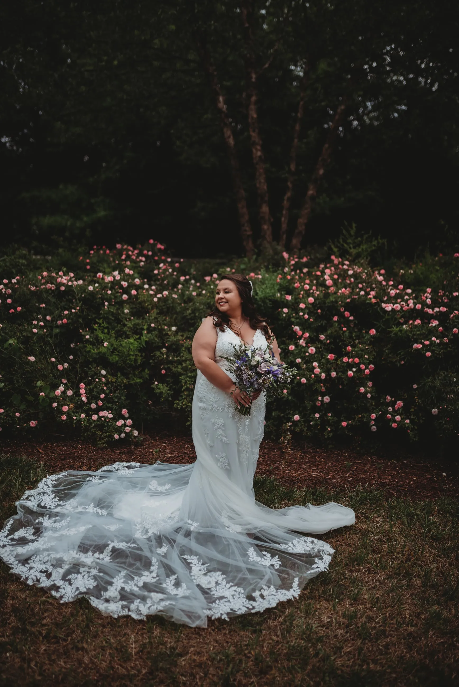 Bride standing for a garden portrait on the grounds at The Heritage Barn