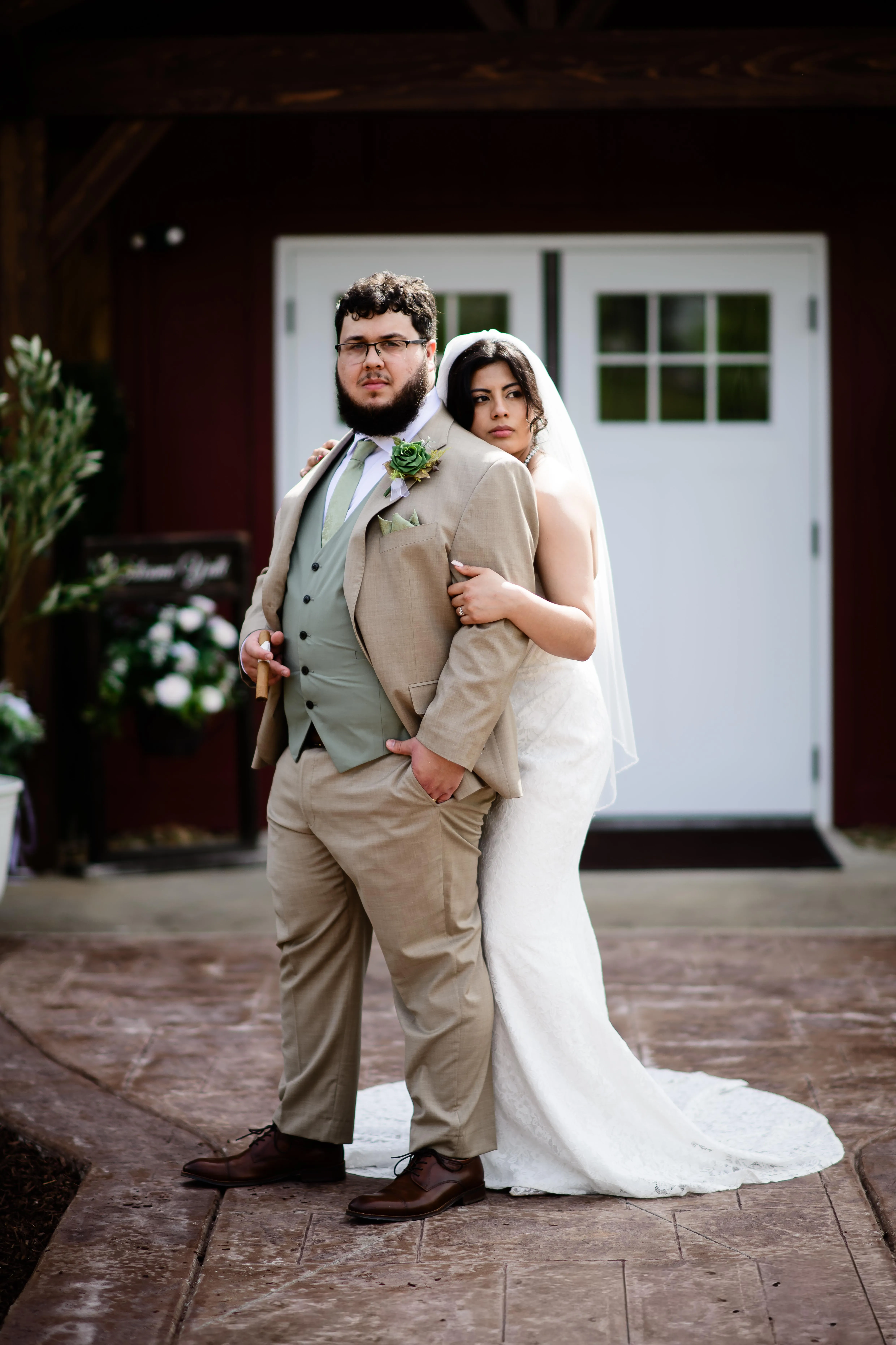Couple posing together in front of the barn entrance at The Heritage Barn